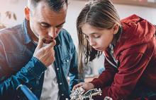 dad and young teen daughter working on a project